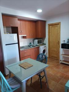 萊魯埃拉的住宿－Peña del Castillo，厨房配有桌子和白色冰箱。
