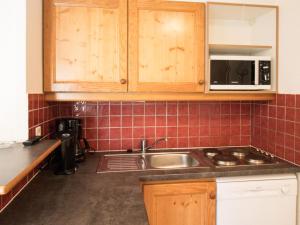 a kitchen with a sink and a microwave at Appartement Lanslevillard, 3 pièces, 6 personnes - FR-1-508-8 in Lanslevillard