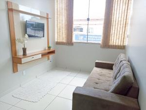 a living room with a couch and two windows at 101-APT-Espaço,conforto.È disso que você precisa! in Anápolis