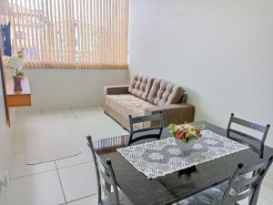 a dining room with a table and a couch at 101-APT-Espaço,conforto.È disso que você precisa! in Anápolis