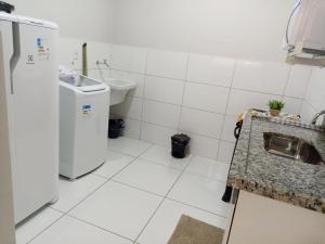 a small kitchen with a sink and a refrigerator at 101-APT-Espaço,conforto.È disso que você precisa! in Anápolis