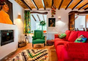 a living room with a red couch and a green chair at Toscana in Benissa