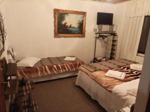 Habitación con 2 camas y una foto en la pared. en Pensiunea La Poarta Bucovinei, en Suceava