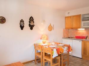 a kitchen with a table and chairs and a kitchen with a counter at Appartement Aussois, 2 pièces, 4 personnes - FR-1-508-148 in Aussois