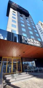 a building with a sign on the side of it at Hotel Black Inn Flamboyant in Goiânia