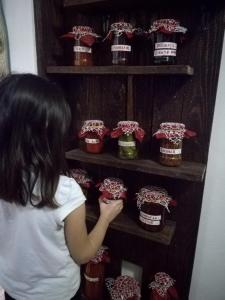 una mujer mirando un estante de plantas con macetas en Pensiunea La Poarta Bucovinei, en Suceava