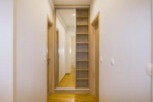 a hallway with a book shelf and a mirror at Luxurious apt near Ampelokipoi Metro station in Athens