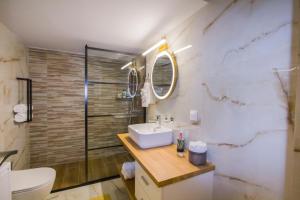 ein Bad mit einem Waschbecken, einem WC und einer Dusche in der Unterkunft Luxurious apt near Ampelokipoi Metro station in Athen