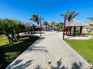 une passerelle dans un parc planté d'arbres et de palmiers dans l'établissement Taíba Beach Resort por Be My Guest!, à São Gonçalo do Amarante