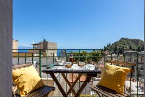 a table and chairs on a balcony with a view at Tauromenion Guest House in Taormina