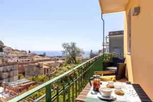 a table on a balcony with a view of the city at Tauromenion Guest House in Taormina