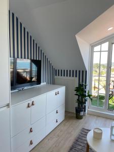 uma sala de estar com uma cómoda branca e uma televisão em Estudio impresionantes vistas con terraza y piscina em Baiona