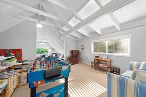 Botanical HideAway Taupo في تاوبو: غرفة معيشة مع طاولة كرة قدم في الوسط