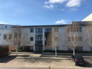 a building with a car parked in a parking lot at Comfortable home, town centre, free parking,Multiple Rooms in Cheltenham