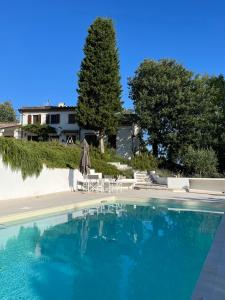 ein Pool mit Stühlen und einem Sonnenschirm und ein Haus in der Unterkunft Casa Sant Angelo in Pesaro