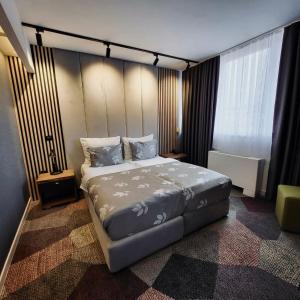 Un dormitorio con una cama grande y una ventana en Hotel City View Deluxe en Sarajevo