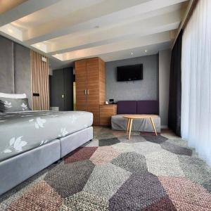 Hotel City View Deluxe في سراييفو: غرفة نوم بسرير وتلفزيون بشاشة مسطحة