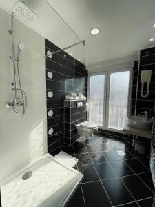 a black and white bathroom with a shower and a sink at Hotel City View Deluxe in Sarajevo +54 photos