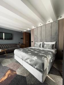 ein Schlafzimmer mit einem großen Bett und einem Sofa in der Unterkunft Hotel City View Deluxe in Sarajevo