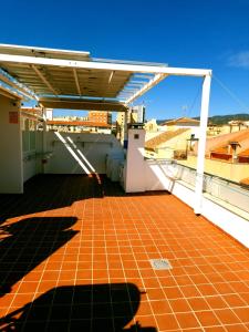 a balcony with a tile floor and a roof at APARTAMENTOS ELEMAR free luggage storage in Málaga