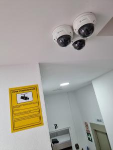 two lights on a ceiling with a sign on a wall at APARTAMENTOS ELEMAR free luggage storage in Málaga