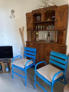 dos sillas azules sentadas junto a un armario de madera en Bel appartement idéalement situé en Haute Corse, en Lumio