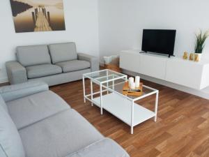 a living room with a couch and a tv at Piso en Muxía con magníficas vistas al mar in Muxia