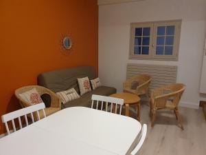 - un salon avec un canapé et des chaises dans l'établissement Le Patio de la Madone, à Le Givre