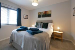 um quarto com uma cama com toalhas azuis em Crewe Short Lets 6 Victoria Court, Crewe em Crewe