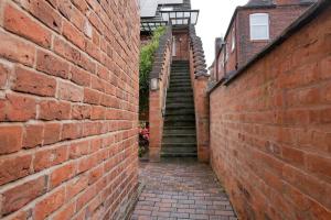 a brick alley with a staircase in a brick wall at Crewe Short Lets 6 Victoria Court, Crewe in Crewe