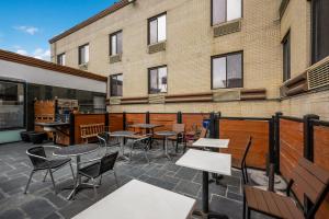 a patio with tables and chairs in front of a building at Quality Inn JFK Airport Rockaway Blvd in Queens
