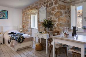 a bedroom with a bed and a stone wall at Stayeva 11 in Dubrovnik