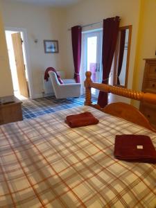 um quarto com uma cama com um cobertor xadrez em Pinetree Cottage, dog friendly, Holiday let, Callander Invertrossachs em Callander