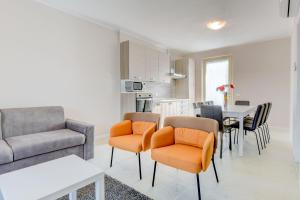 ein Wohnzimmer mit einem Sofa, einem Tisch und Stühlen in der Unterkunft Le Ville della Romantica in Manerba del Garda