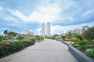 a walking path in a city with tall buildings at Apartment Fabulous in Bat Yam