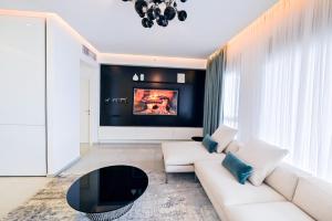 a living room with a white couch and a tv at Apartment Fabulous in Bat Yam