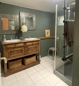 uma casa de banho com 2 lavatórios e um chuveiro em Ferme St Pierre gîte autonome 2-4 personnes em Chabeuil