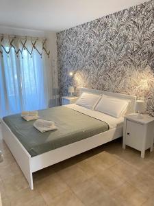 Apartamento bajo con piscina "Macarella" في كالا إن بلانيس: غرفة نوم بسرير ابيض كبير وورق جدران