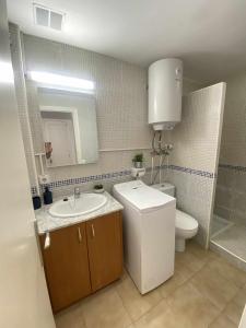 Apartamento bajo con piscina "Macarella" في كالا إن بلانيس: حمام مع حوض ومرحاض ومرآة