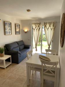 Apartamento bajo con piscina "Macarella" في كالا إن بلانيس: غرفة معيشة مع أريكة وطاولة وكراسي