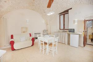 ein Wohnzimmer mit einem Stuhl und einem Tisch in der Unterkunft Dimora Alfieri in Cisternino