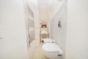 Baño blanco con aseo y lavamanos en Dimora Alfieri, en Cisternino