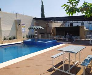 a swimming pool with a table and a patio at Hotel POSADA DEL REY in Matamoros