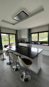 a kitchen with a black counter and chairs in it at Casa da Falperra in Arcos de Valdevez