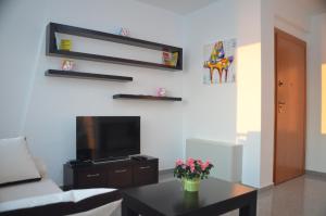 uma sala de estar com um sofá, uma televisão e uma mesa em Home Sweet Home by the Sea - 060 em Durrës