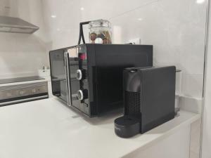 a kitchen with a microwave and a computer monitor at Casa Mini-Ventuzelo by JC in Porto