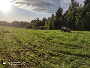 レシナにあるGórska Ostoja pole kempingowo- kamperoweの太陽を背景にした野原トラクター