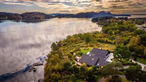 z góry widok na duże jezioro z domem w obiekcie Villa Arboretet - Seaside villa with private pool & infrared sauna in the heart of Arboretet, Bergen w Bergen