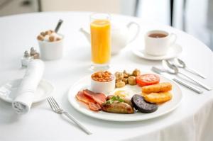 een tafel met een bord ontbijtproducten en koffie bij Town Gates Hotel in Baku