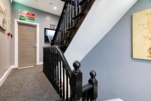 een trap met zwarte relingen in een huis bij Harewood Lodge Darlington Luxury Apartments in Darlington